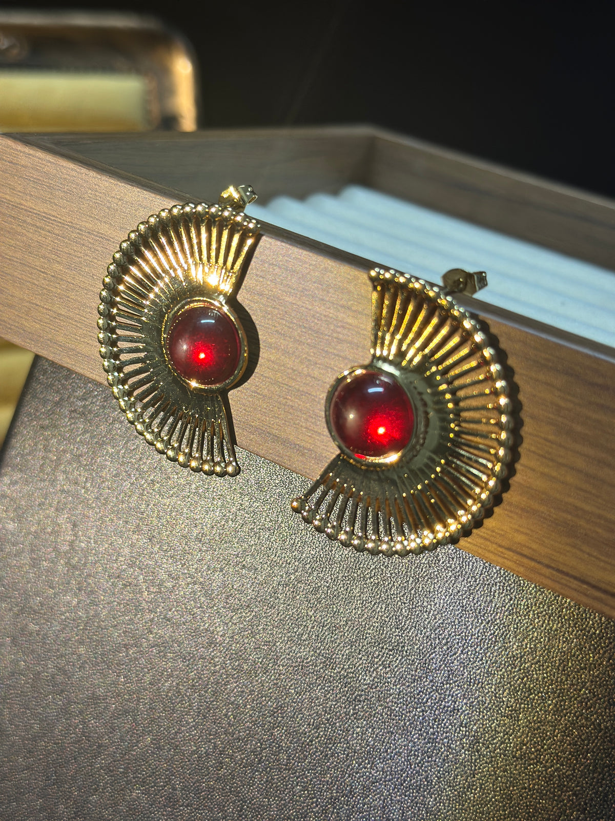 Red stone fan stud earrings with glossy red centres, gold-tone sunburst ridges and textured beaded edges