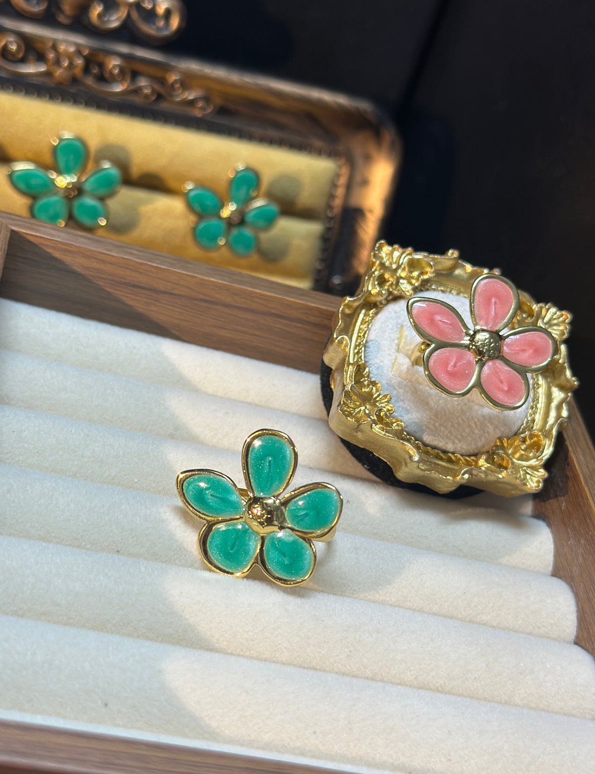 Set of two adjustable five-petal flower rings in pink and teal green with gold-tone details