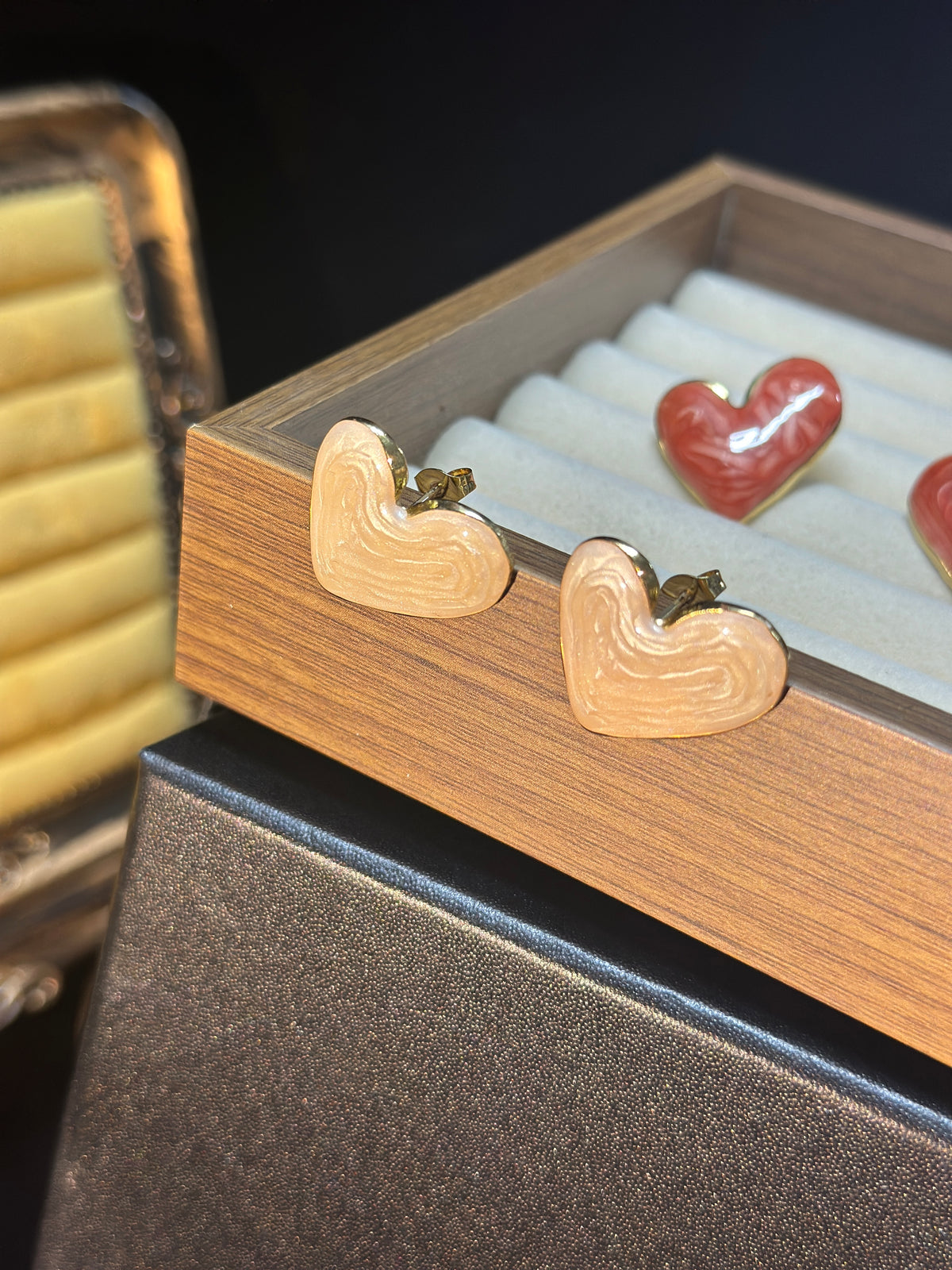 Pearl white heart stud earrings with a luminous pearlescent finish, subtle flowing textures and delicate gold-tone edges