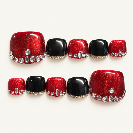 Red glitter and black handmade press-on toenails with champagne-gold glitter edges and crystal embellishments