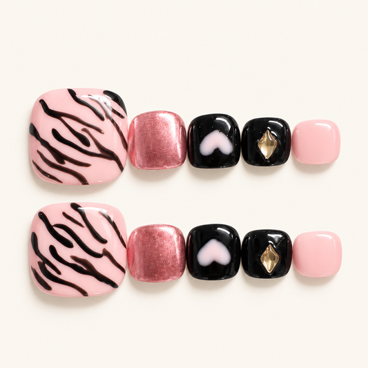 Pink and black animal print press-on toenails with rose-pink shimmer, pink heart details and a gold-toned accent
