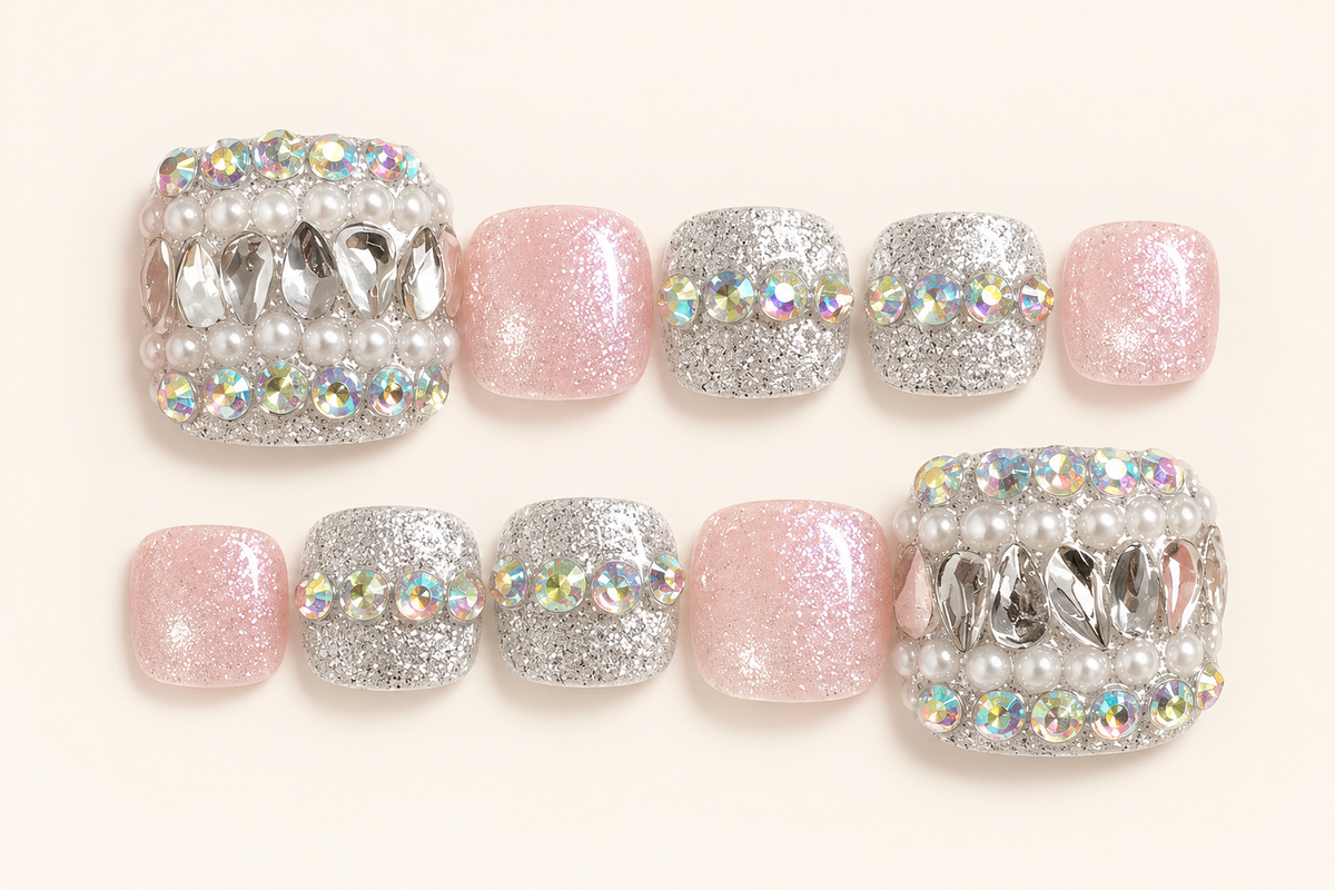 Pink and silver glitter press-on toenails with pearl-like embellishments, iridescent accents and reflective silver decorations