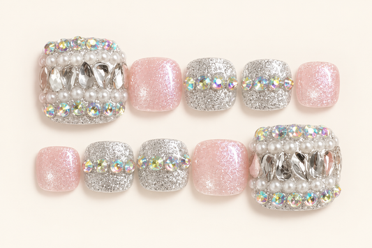 Pink and silver glitter press-on toenails with pearl-like embellishments, iridescent accents and reflective silver decorations