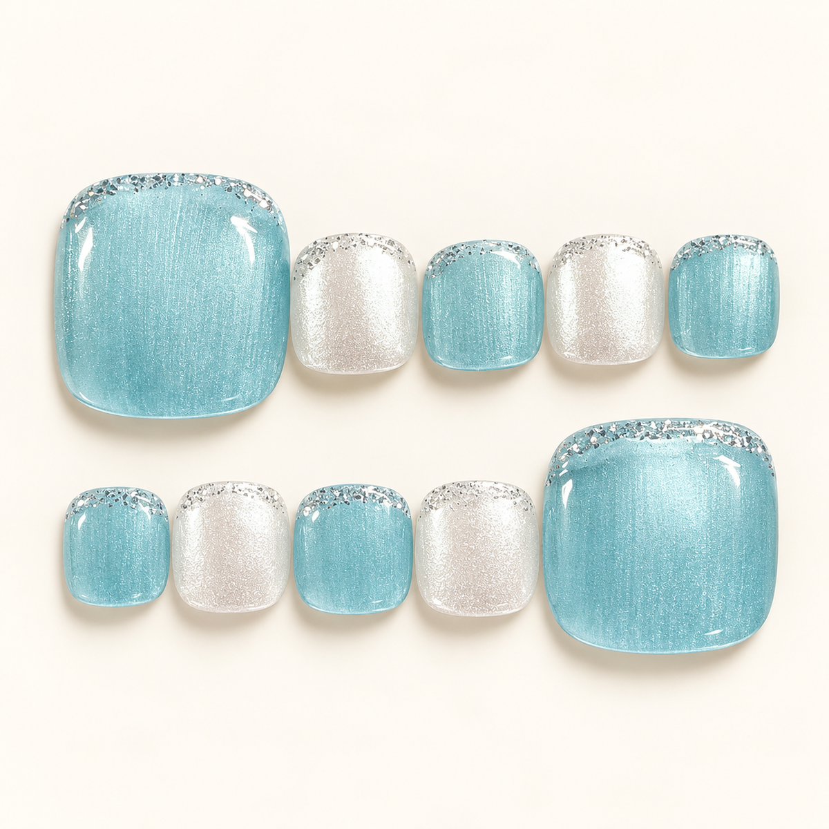 Ice blue and silver-white shimmer press-on toenails with a glossy, frosty finish